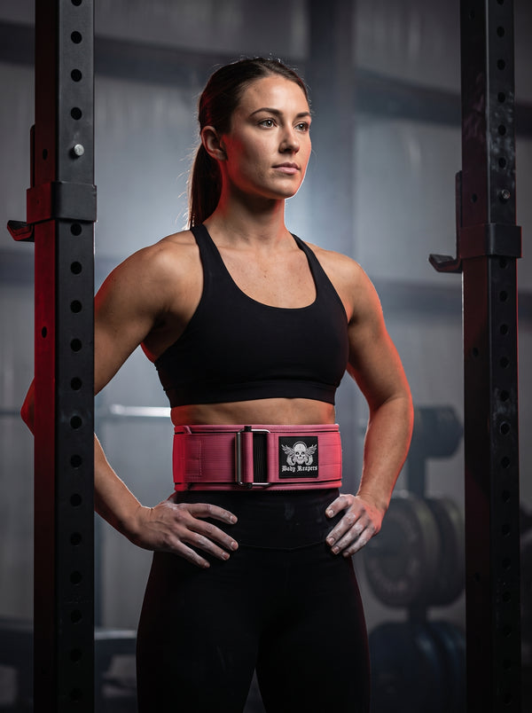 Female athlete wearing the Body Reapers pink auto-locking weightlifting belt at a squat rack