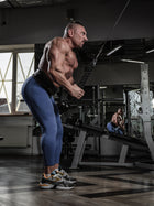 Male athlete wearing the Body Reapers 10mm lever belt during a full-body cable workout, side view
