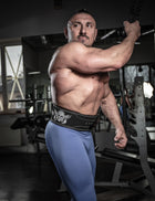 Male athlete wearing the Body Reapers 10mm lever belt across the waist during a cable exercise, torso and belt visible