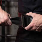 Close-up of a lifter's hands locking the Body Reapers stainless auto-locking roller buckle